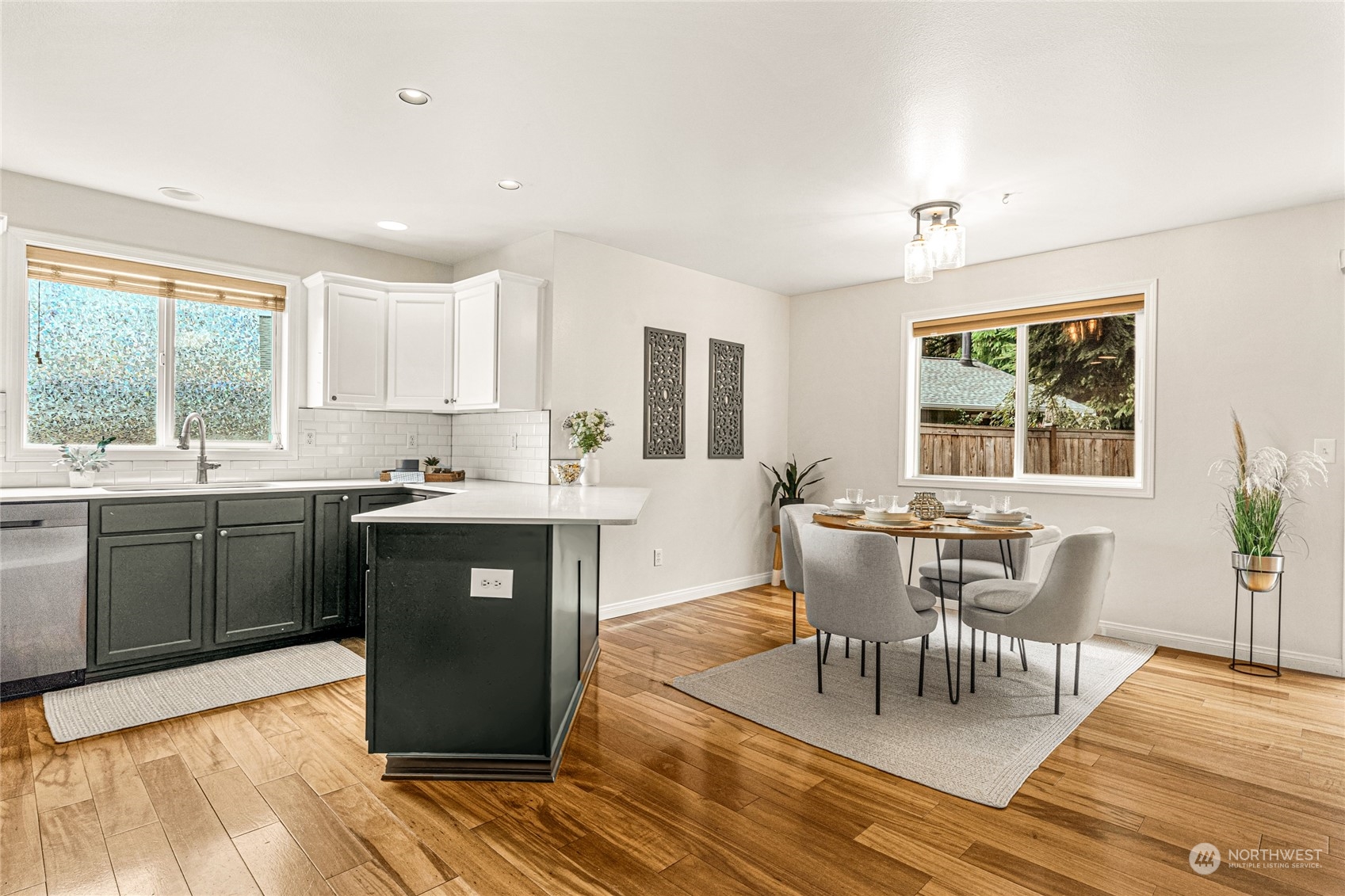 6712 Lower Ridge Road Everett, WA 98203 - Photo 12 of 34 a kitchen with stainless steel appliances granite countertop a stove top oven a sink dishwasher a dining table and chairs with wooden floor