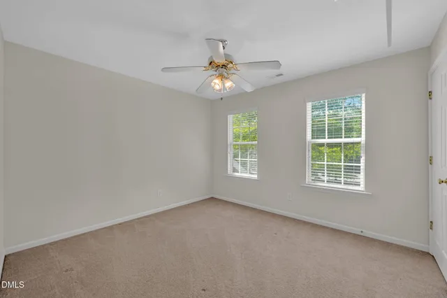 an empty room with window and chandelier fan