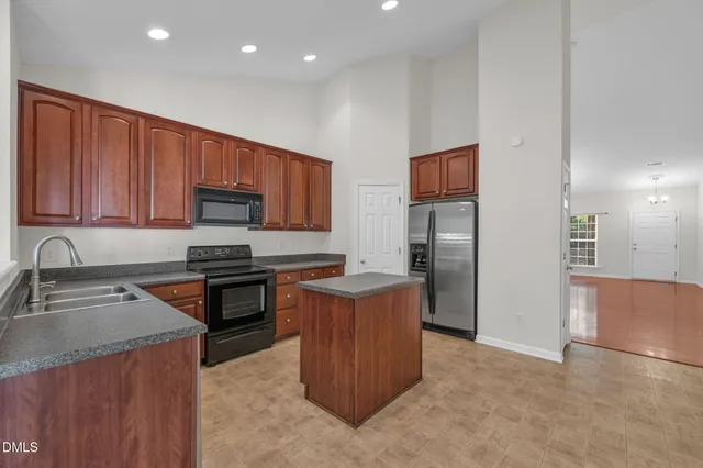 a kitchen with kitchen island wooden cabinets stainless steel appliances and a sink