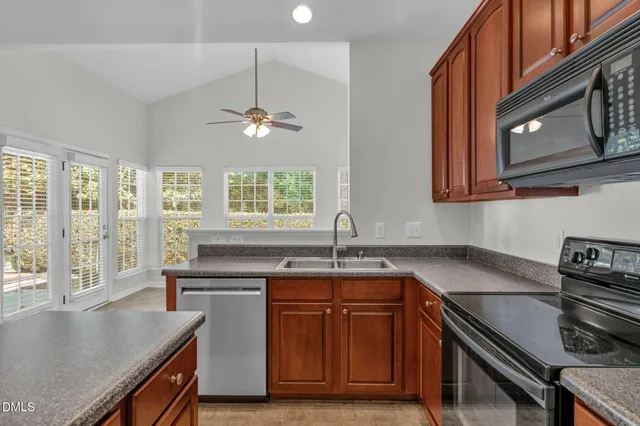 a kitchen with stainless steel appliances granite countertop a sink a stove counter space and cabinets