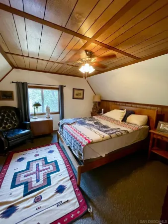 a black leather couch in a bedroom next to a window