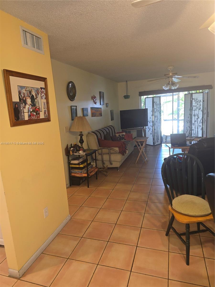 21121 Southwest 85th Avenue, Unit 105 Cutler Bay, FL 33189 - Photo 12 of 13 a living room with furniture a flat screen tv and a table