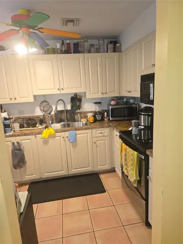 a kitchen with a sink a stove cabinets and a window