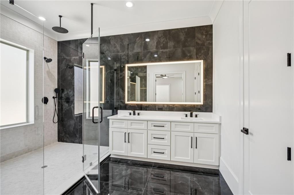 4546 Fawn Path Gainesville, GA 30506 - Photo 46 of 64 a bathroom with a double vanity sink a mirror a bathtub and shower