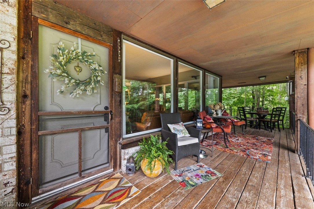 171 Granger Road, Unit 107 Medina, OH 44256 - Photo 5 of 41 Covered outdoor porch featuring wood-finish flooring, exposed wood beams, and a brick exterior wall
