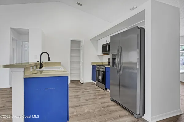 a kitchen with granite countertop a refrigerator and a sink