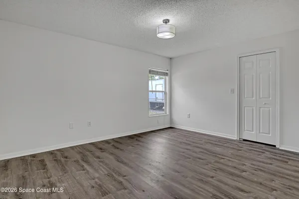 an empty room with wooden floor and window
