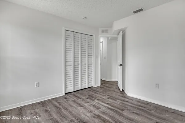 an empty room with wooden floor and white walls