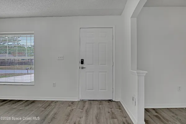 a view of hallway with wooden floor and cabinet