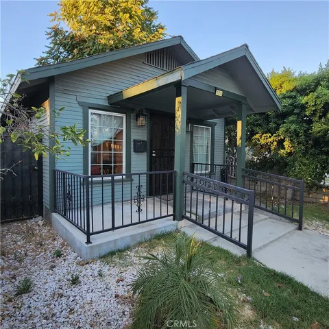 a view of a house with a small yard and wooden fence