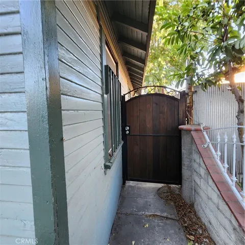 a view of a house with a small yard and wooden floor and fence