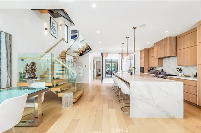 a open kitchen with stainless steel appliances granite countertop a stove and a view of living room with furniture