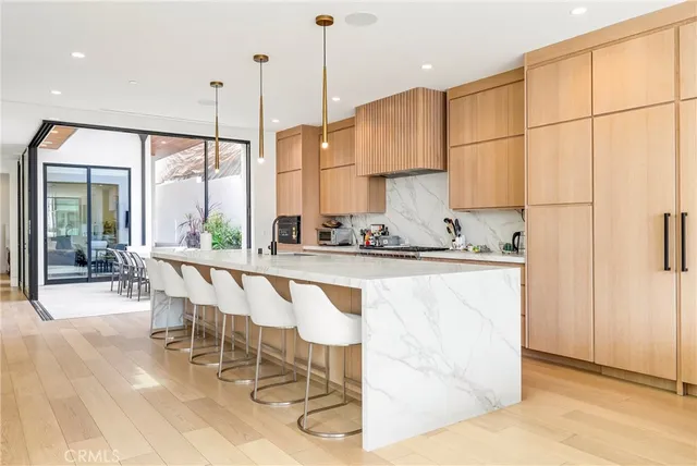 a kitchen with sink stove and white cabinets with wooden floor