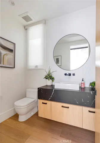 a bathroom with a granite countertop sink a toilet and a mirror