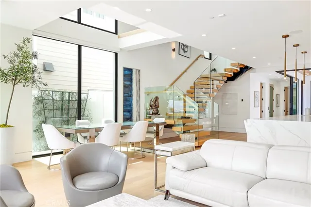 a living room with furniture a large window and kitchen view