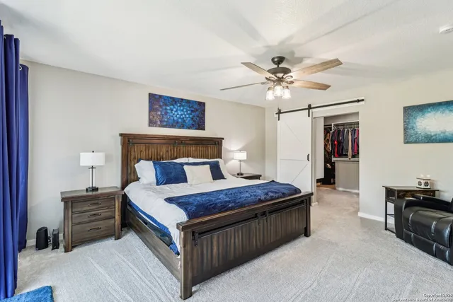 a bedroom with a bed dresser and a chandelier