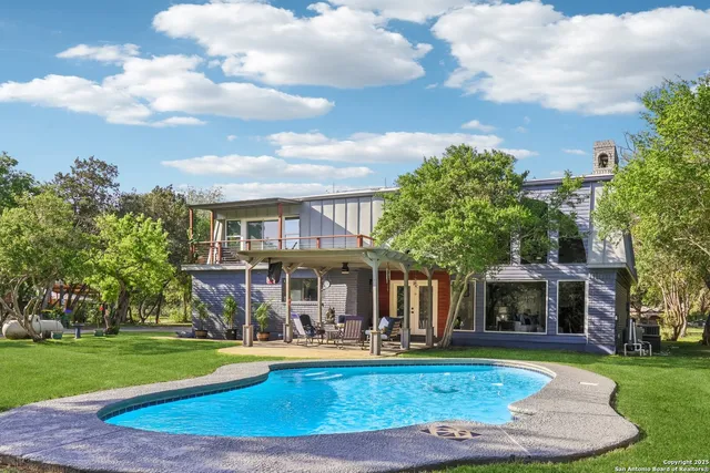 a view of a house with swimming pool and a yard