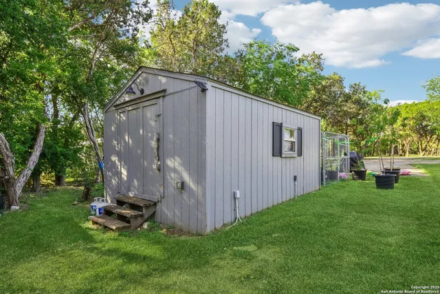 a view of a backyard with wooden fence and a bench