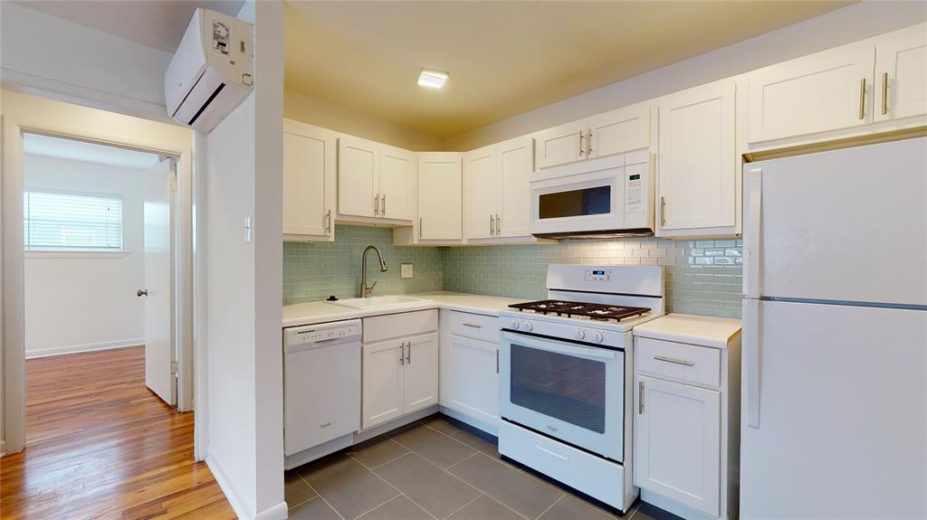 a kitchen with stainless steel appliances granite countertop white cabinets a sink a stove a refrigerator and white cabinets