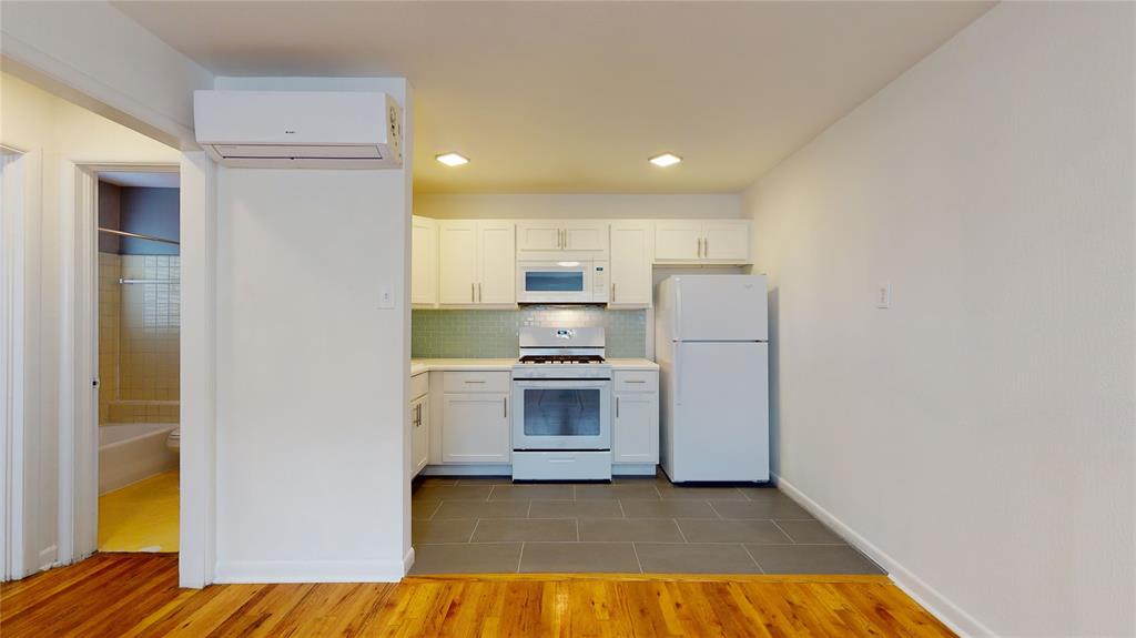 2405 Abrams Road, Unit A1 Dallas, TX 75214 - Photo 4 of 9 a kitchen with a refrigerator and a stove top oven