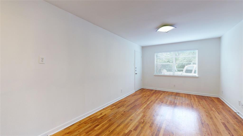 2405 Abrams Road, Unit A1 Dallas, TX 75214 - Photo 5 of 9 an empty room with wooden floor and windows