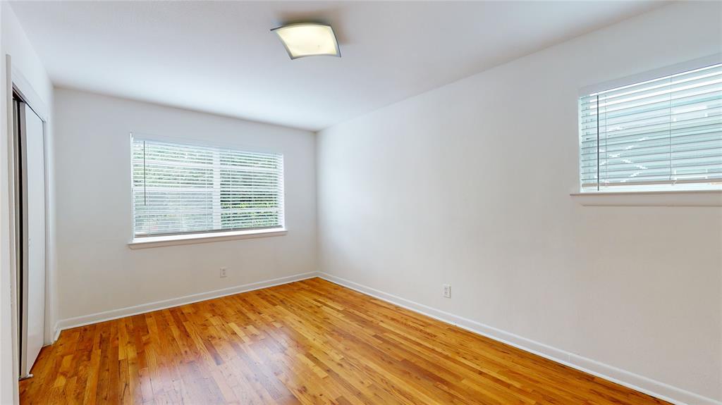 2405 Abrams Road, Unit A1 Dallas, TX 75214 - Photo 6 of 9 an empty room with wooden floor and windows