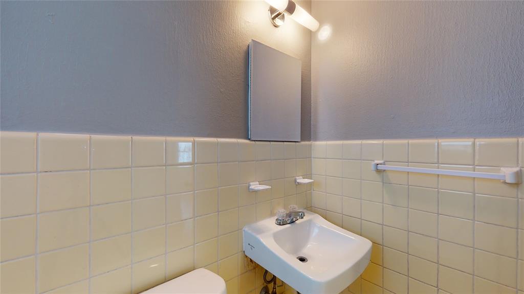 2405 Abrams Road, Unit A1 Dallas, TX 75214 - Photo 8 of 9 a bathroom with a toilet sink and mirror