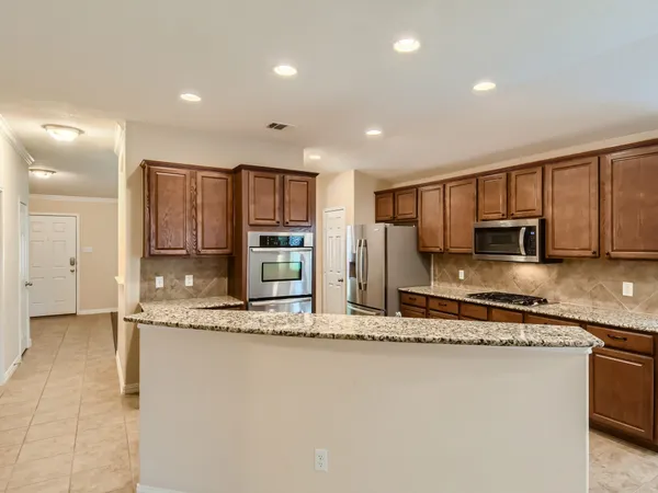 a kitchen with stainless steel appliances granite countertop a sink stove and cabinets