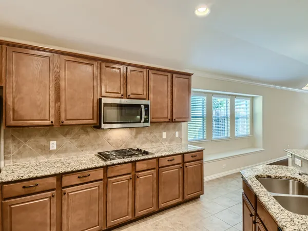 a kitchen with granite countertop a stove and a sink