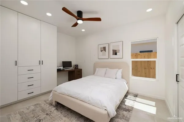 a bedroom with a large bed and a chandelier