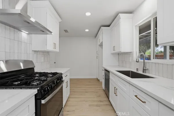 a kitchen with granite countertop stainless steel appliances sink and cabinets