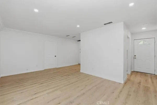 a view of an empty room with wooden floor