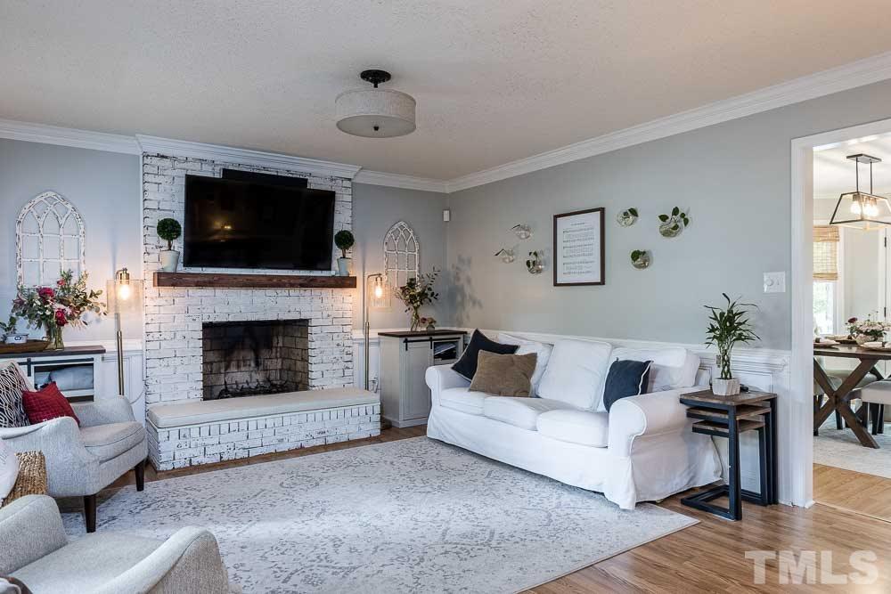 1590 Ranch Road Clayton, NC 27520 - Photo 11 of 26 a living room with furniture a flat screen tv and a fireplace