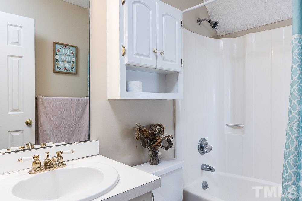 1590 Ranch Road Clayton, NC 27520 - Photo 20 of 26 a bathroom with a sink a tub and a mirror