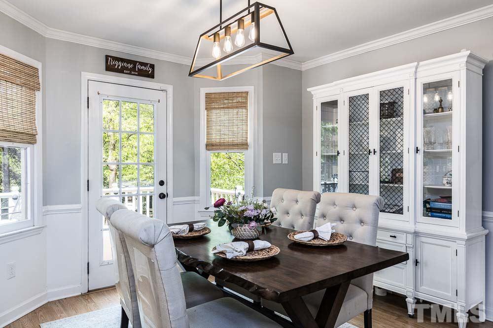 1590 Ranch Road Clayton, NC 27520 - Photo 9 of 26 a view of a dining room with furniture large windows and wooden floor