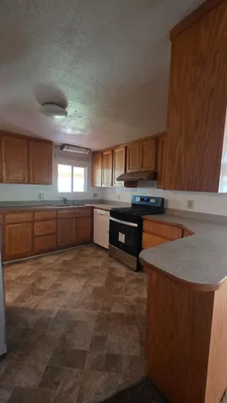 a kitchen with stainless steel appliances granite countertop a stove a sink and a microwave
