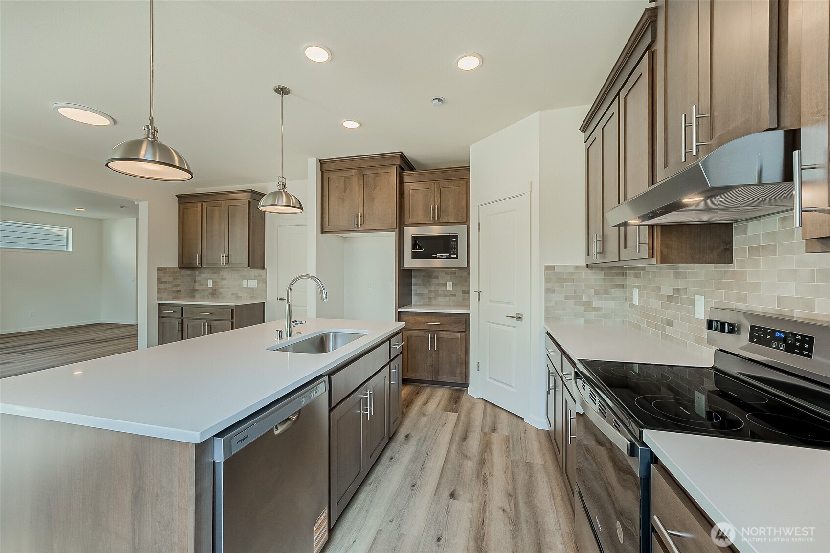 960 RW Fletcher Street Winlock, WA 98596 - Photo 6 of 40 a kitchen with a sink dishwasher a stove and a refrigerator with wooden floor