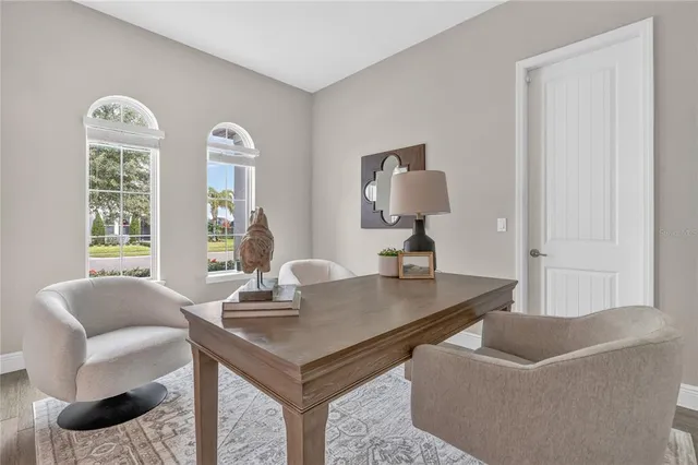 a kitchen with stainless steel appliances kitchen island granite countertop a table chairs and a refrigerator