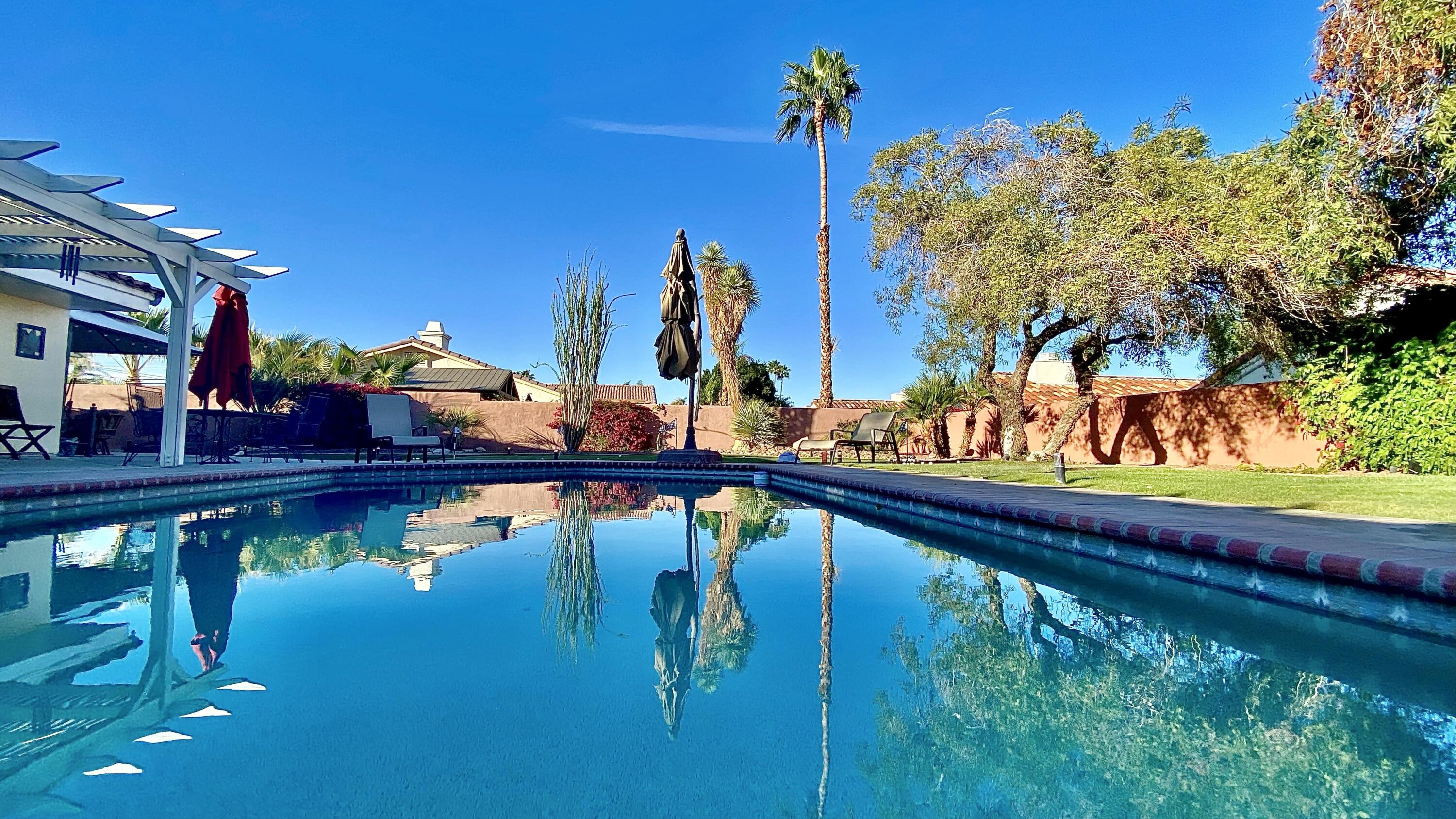 43622 Warner Trail Palm Desert, CA 92211 - Photo 40 of 51 a view of a swimming pool with a patio and a garden