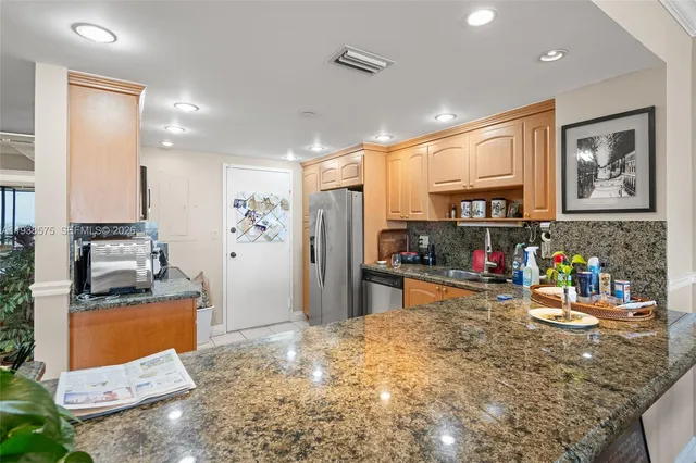 a kitchen with stainless steel appliances granite countertop a refrigerator and stove
