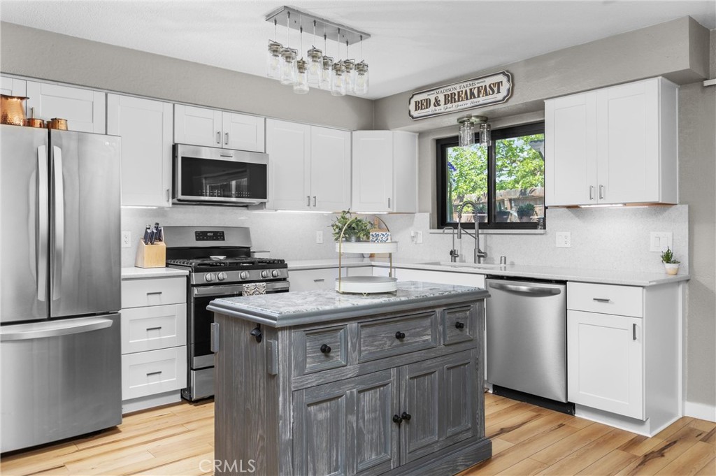 4913 Sparrow Hawk Lane Paso Robles, CA 93446 - Photo 13 of 33 a kitchen with stainless steel appliances granite countertop a stove a sink dishwasher a refrigerator and a microwave oven with wooden floor