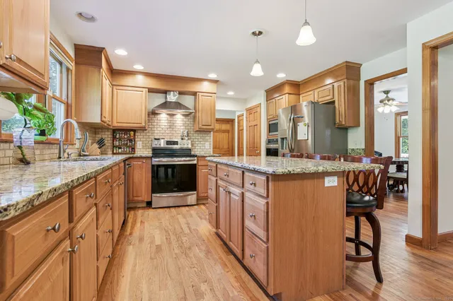 a kitchen with stainless steel appliances granite countertop a stove and cabinets