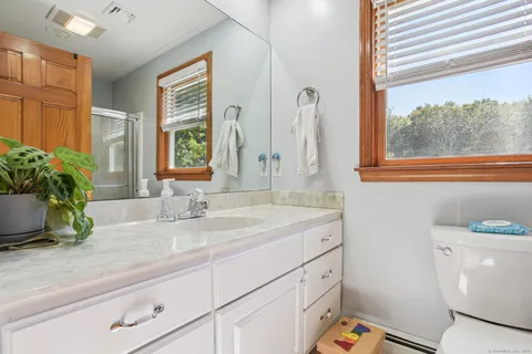 a bathroom with a sink a mirror and a window