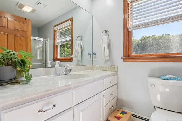 a bathroom with a sink a mirror and a window