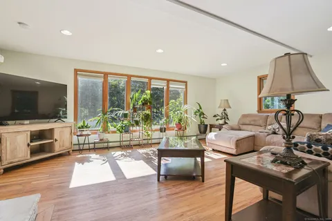a living room with furniture a flat screen tv and a floor to ceiling window