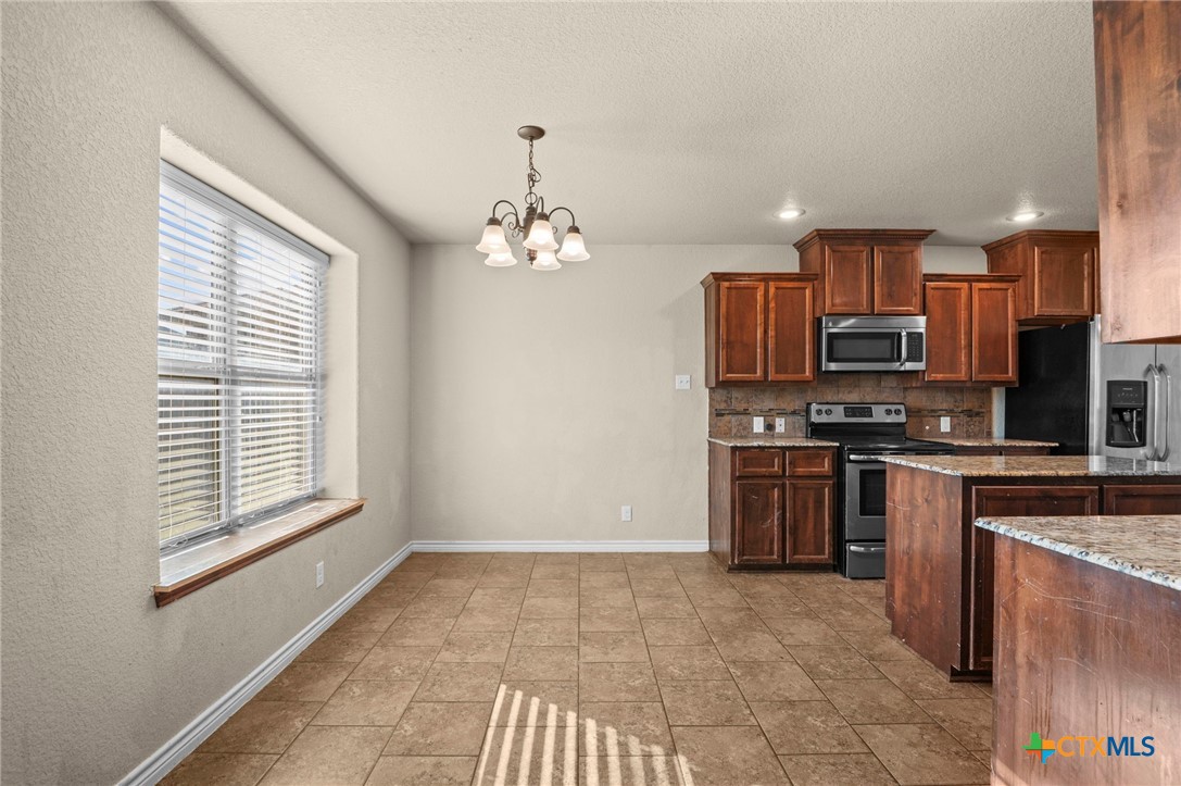 3710 Anvil Range Road Killeen, TX 76549 - Photo 11 of 32 a kitchen with stainless steel appliances granite countertop a stove top oven a sink a counter space and cabinets