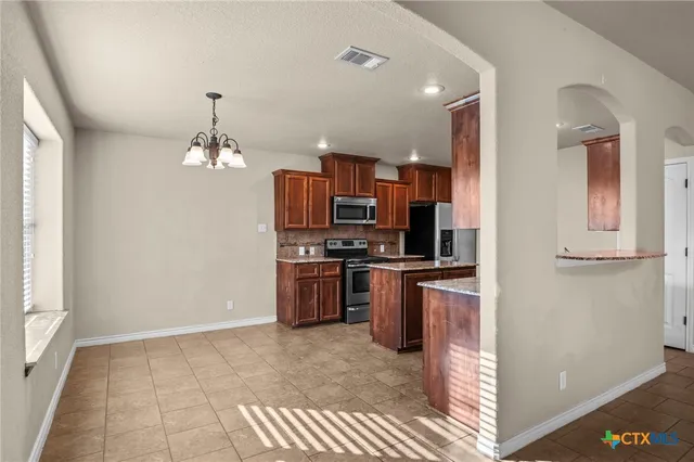 a kitchen with stainless steel appliances a refrigerator and a stove top oven