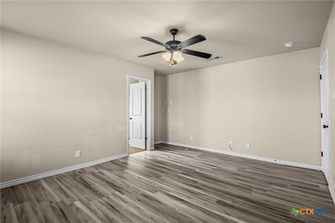 3710 Anvil Range Road Killeen, TX 76549 - Photo 17 of 32 a view of an empty room with wooden floor and a ceiling fan