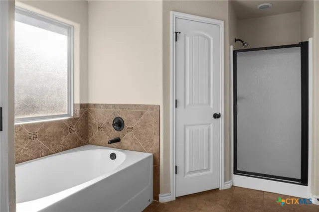 a bathroom with a tub a sink and a window