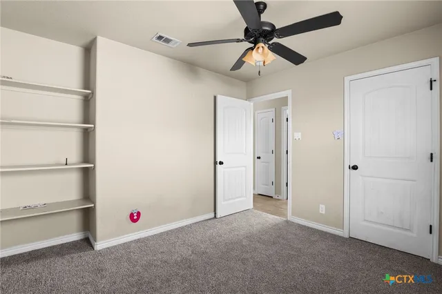 a view of an empty room with a ceiling fan
